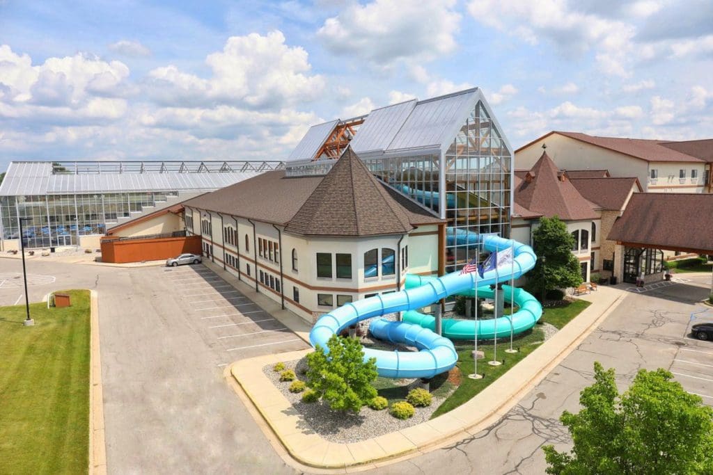 An aerial view of Zehnder’s Splash Village Hotel and Water Park, featuring its indoor waterpark slide that going out of the building and back into the building.