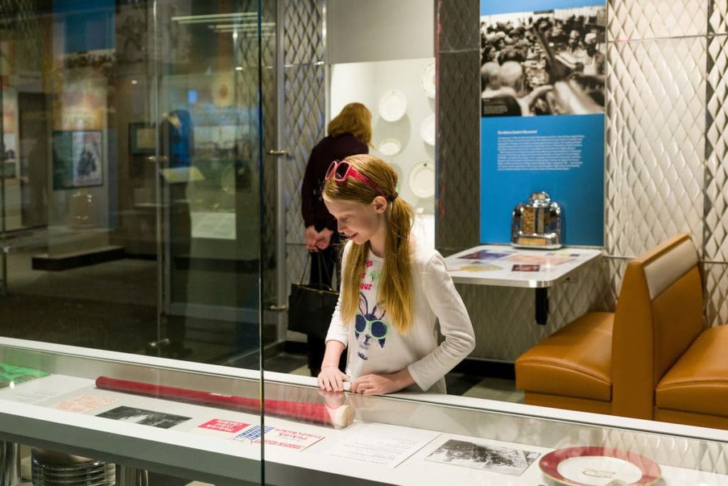 A pre-teen girl looks on at an exhibit case at the Atlanta History Center, exploring Atlanta Stories.