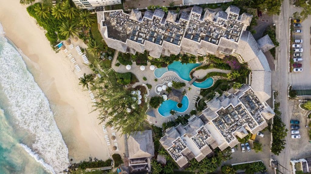 An aerial view of the ocean, beach, and intimate resort ground of Bougainvillea Barbados.