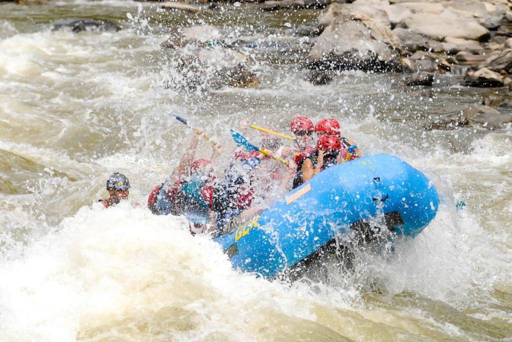 Several people raft down a river in Colorado with Glenwood Canyon Rafting.