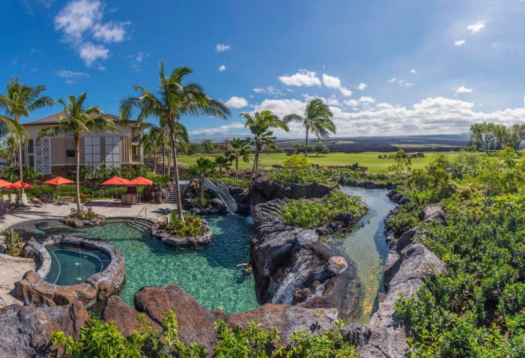 An aerial view of Kings’ Land, a Hilton Grand Vacations Club, featuring its large pool and lush resort grounds.