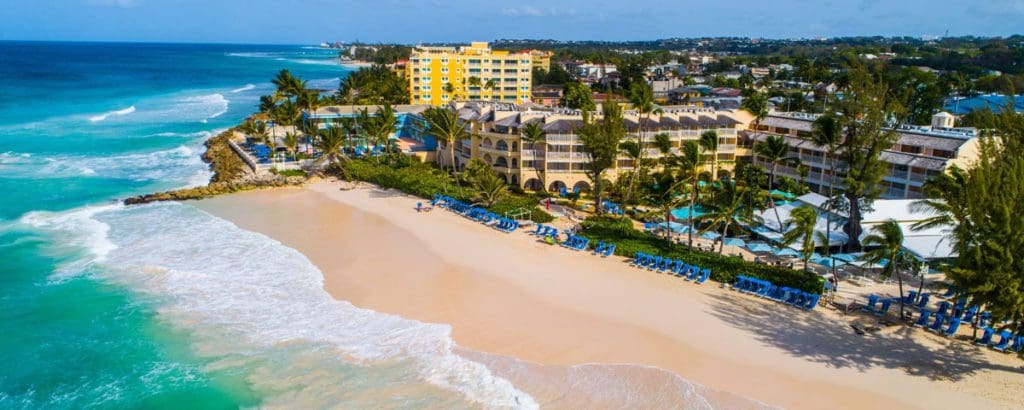 An aerial view of the resort grounds along the pristine shoreline of the Turtle Beach by Elegant Hotels, with turquoise waters on a sunny day.