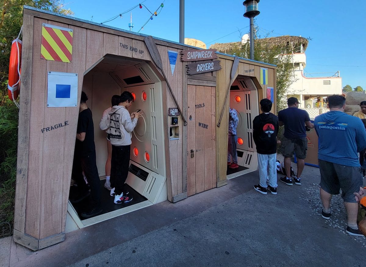 A couple of kids use the large dryers to dry off after a water ride at SeaWorld San Diego.