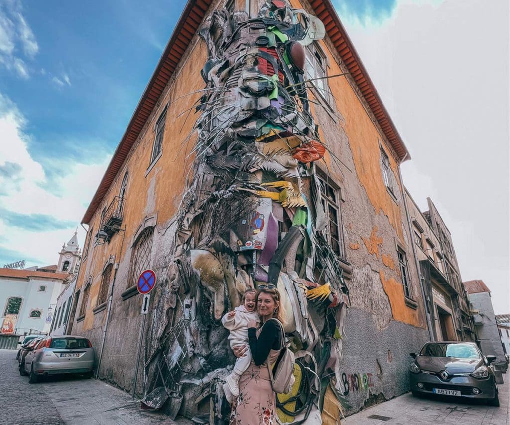 A mom and her toddler daughter stand in front of the colorful Rabbit Mural in Porto.