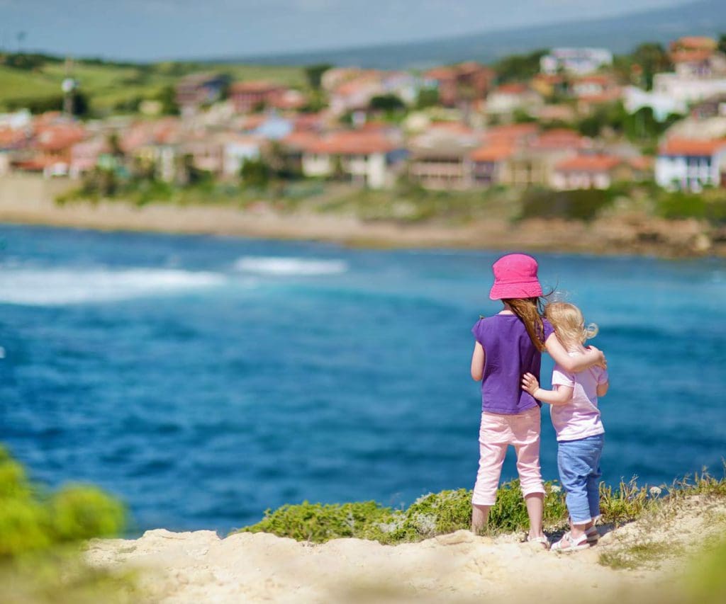 Two young girls stand together looking over the sea onto a view of Istanbul, knowing what to do is part of learning all about Turkey with kids.