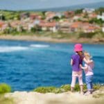 Two young girls stand together looking over the sea onto a view of Istanbul.