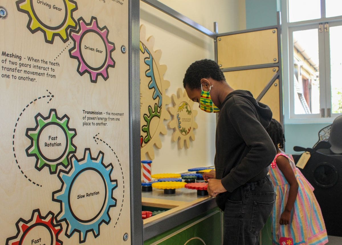 A young boys interacts with an exhibit at the Jairus Brewster Children's Gallery featuring the exhibit 'Explore'.