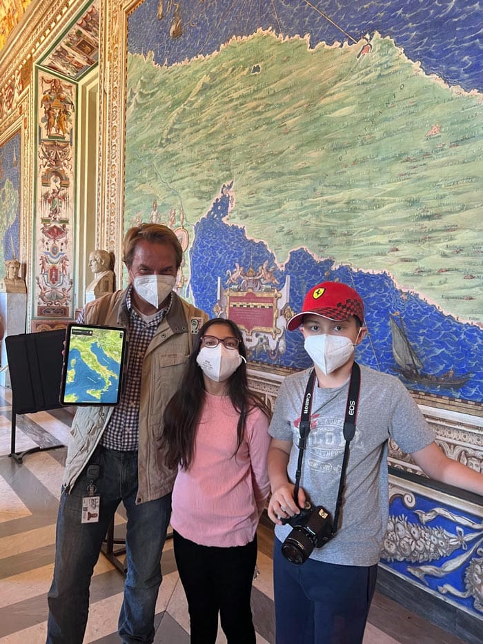 Two kids stand with their private guide, while touring the Vatican in Rome.