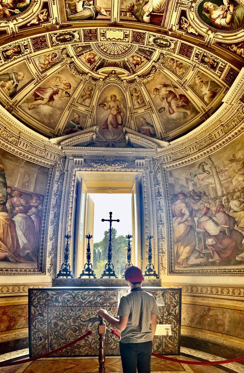 A young boy looks up at a Catholic alter, while touring churches in Rome.