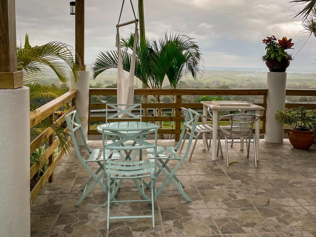 The small patio at an Vrob near Añasco, featuring a turquoise table, hammock, and great view.