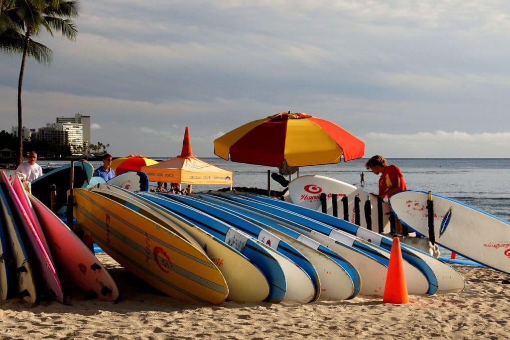 A man stands over a pile of surfboards ready for rent on Waikiki Beach in Oahu.