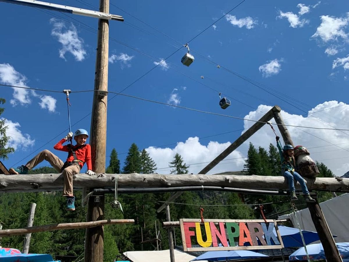 Kids sit atop a ziplining platform near Zermatt.