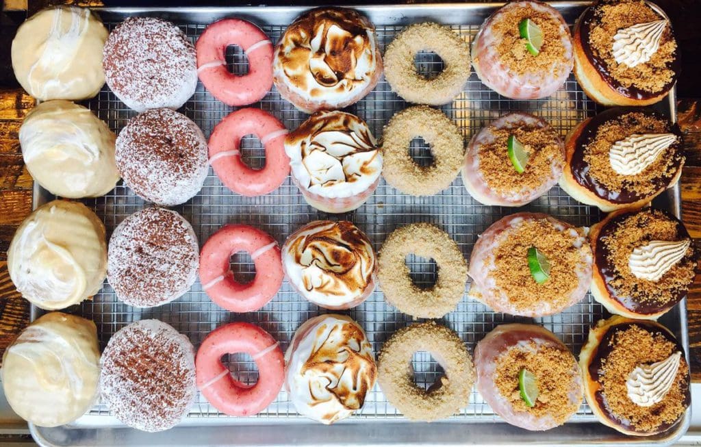 Seven rows of donuts, all of varying flavors, at District Doughnut.