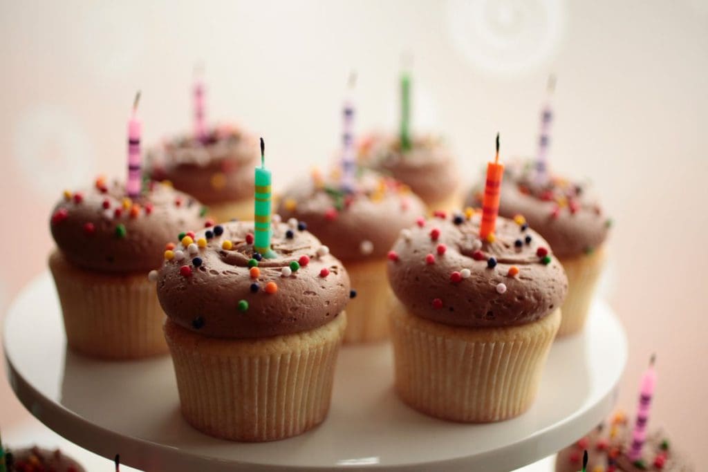 A plated filled with gourmet cupcakes with chocolate frosting, sprinkles, and candles at Georgetown Cupcake, one of the best dessert spots in DC for families.