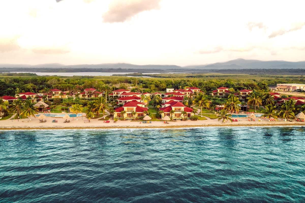 Hopkins Bay Belize, a Muy’Ono Resort nestled along the beach on a sunny day.