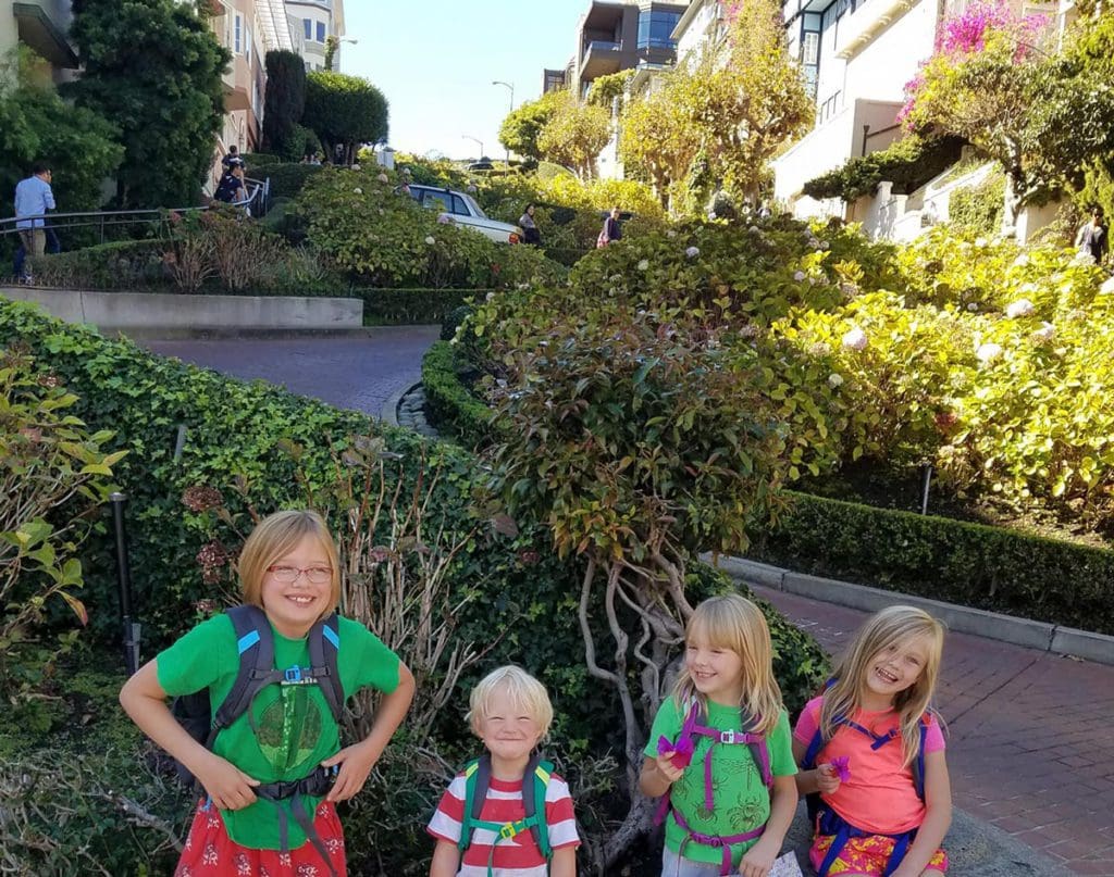 Four kids smile while exploring Lombard Street, one of the best things to do in San Francisco with kids.