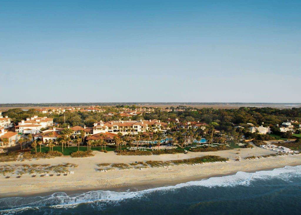 An aerial view of the beach at The Cloister at Sea Island, where blue water meets soft sand on the Georgia coast.