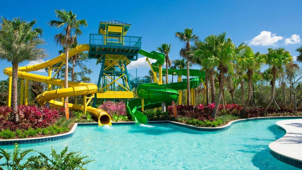 Two large water slides over a pool at The Grove Resort & Water Park Orlando.