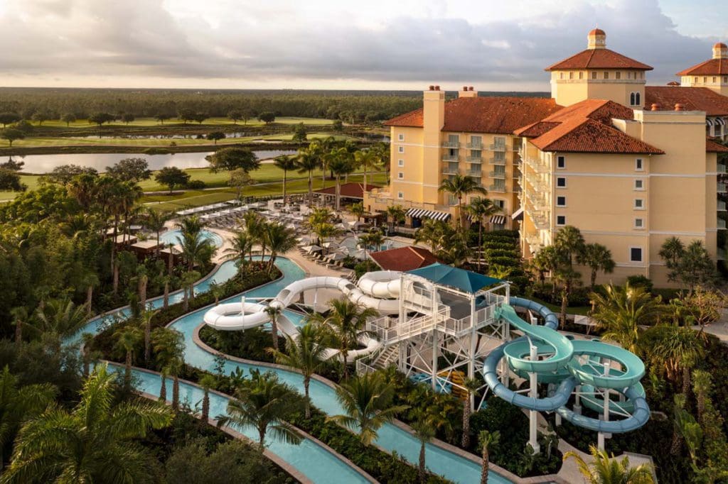 An aerial view of the three water slides near the resort buildings at The Ritz-Carlton Golf Resort, Naples at sunset.