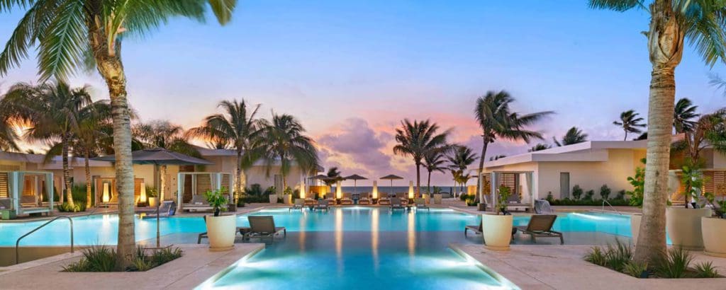 The charming pool and surrounding pool deck at Alaia Belize, Autograph Collection at dusk, one of the best Belize resorts for a family vacation!