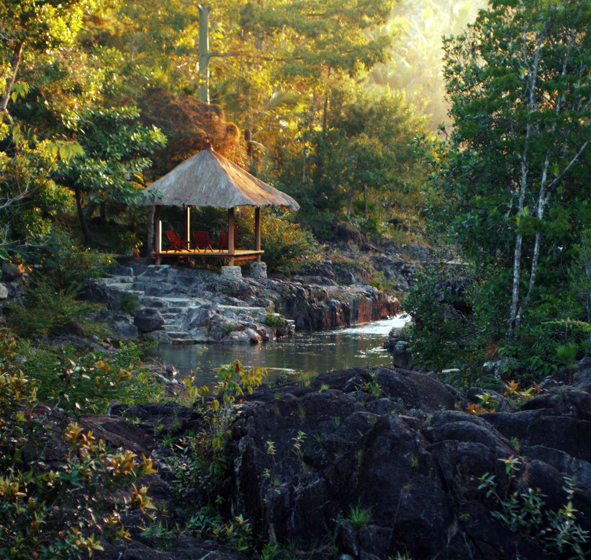 A platform seating area, surrounded by jungle foliage, at Blancaneaux Lodge, one of the best Belize resorts for a family vacation.