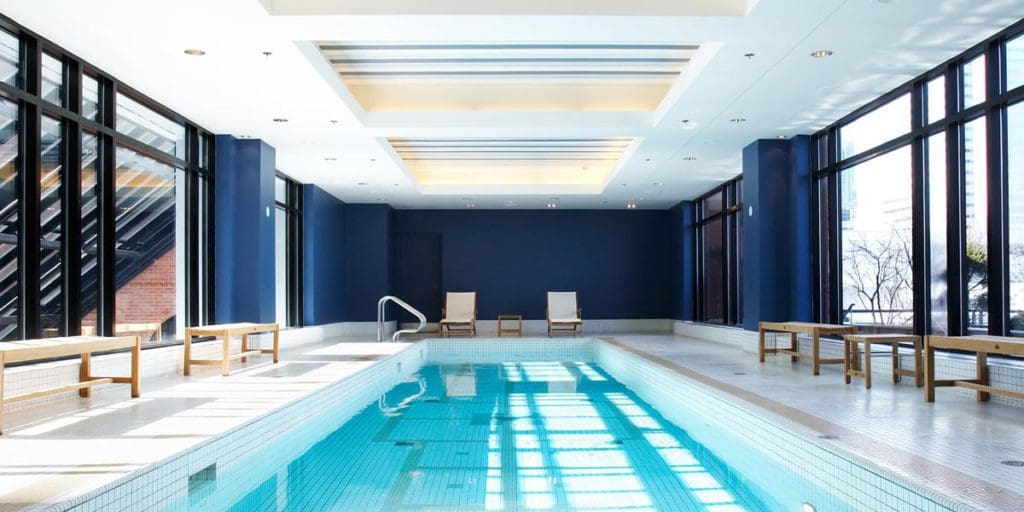 The indoor pool, with floor to ceiling windows on all sides, at InterContinental Montreal, an IHG Hotel.