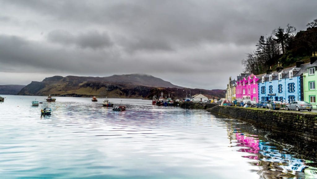 A row of colorful houses on the shoreline of the Isle of Skye, one of the best mild weather European destinations for a family summer vacation.