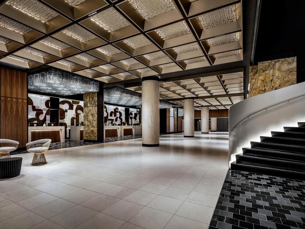 The large lobby of the Fairmont The Queen Elizabeth, in hues of dark brown and black.