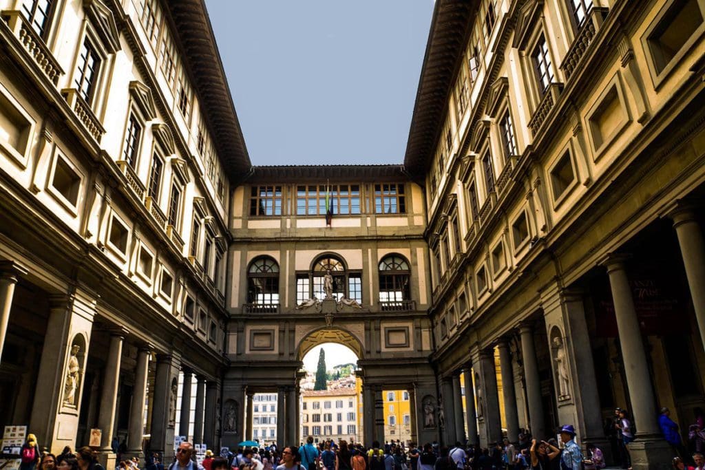 Inside the open courtyard of the Uffizi Gallery, looking up at the sky.