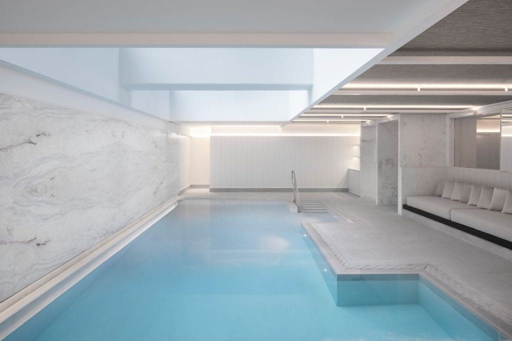 The luxurious indoor pool, with classic white pool bench at Four Seasons Hotel Montreal.