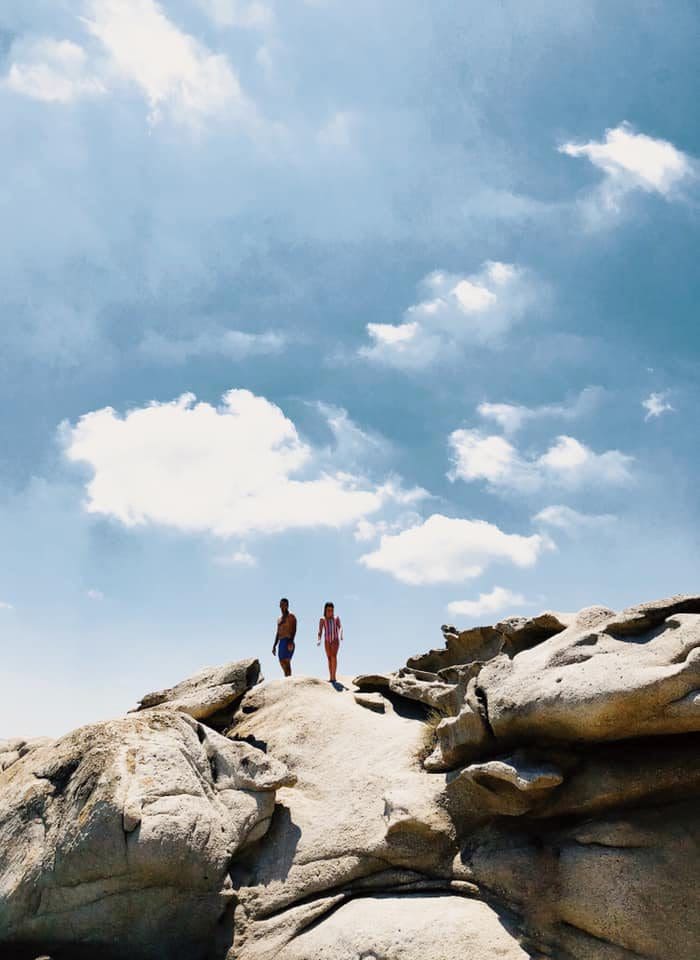 Two kids stand atop a rocky area in Naxos.