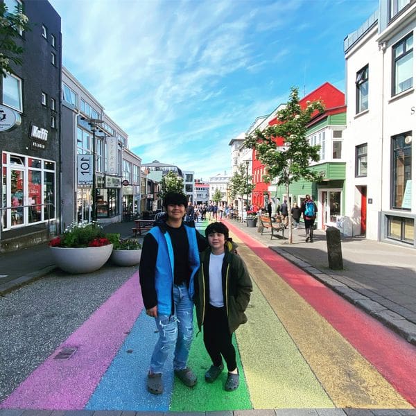 Two boys stand together on the iconic rainbow road of Reykjavik, the first stop on this Iceland itinerary for families.