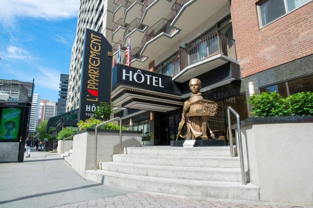 The grand entrance to the L'Appartement Hôtel on a sunny day.