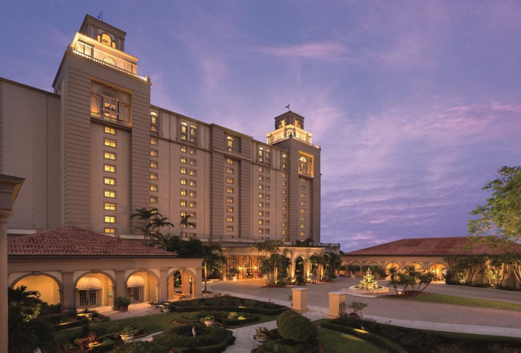 The large resort building front exterior and entrance of The Ritz-Carlton, Naples, one of the best eco-friendly hotels in the United States for families.