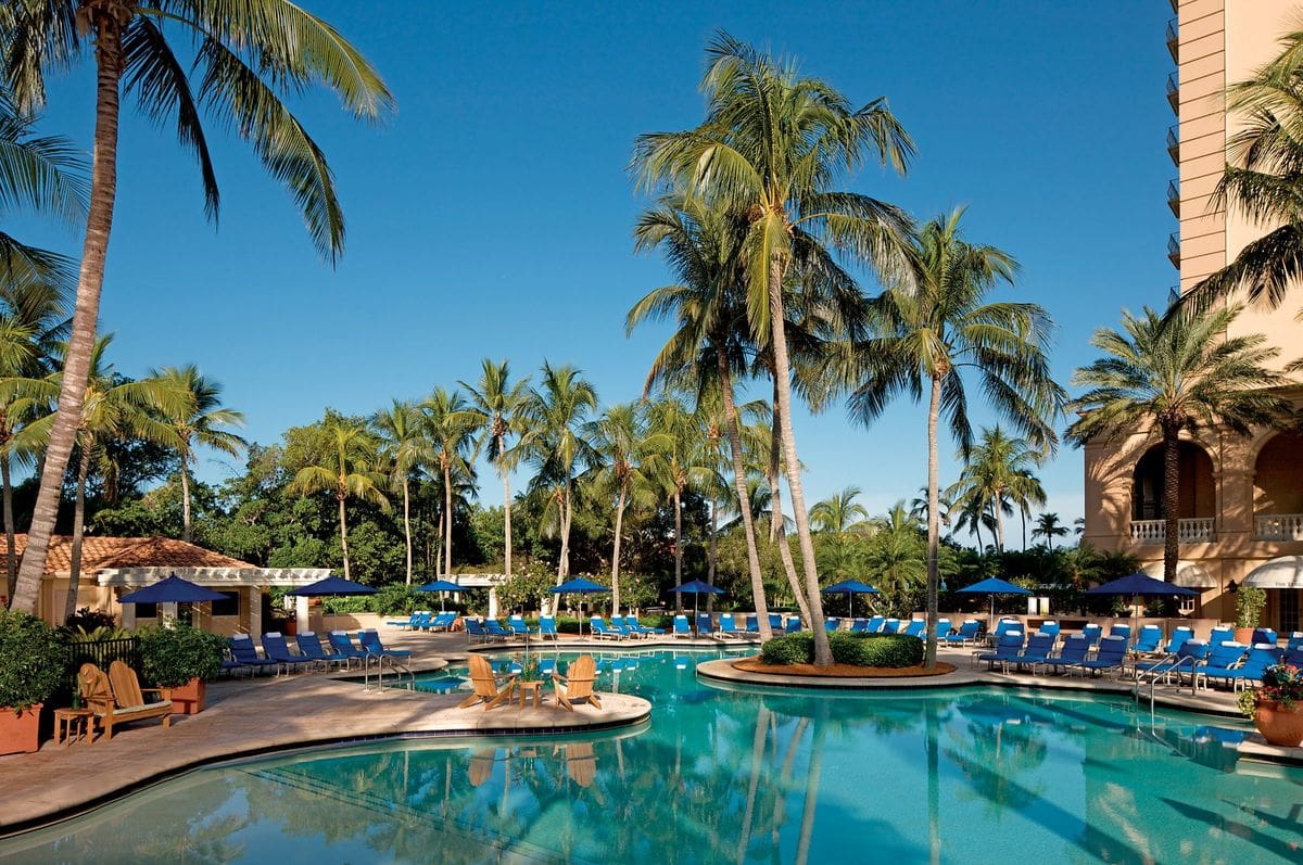 The large pool, with surrounding palm trees, at The Ritz-Carlton Naples, Tiburón.