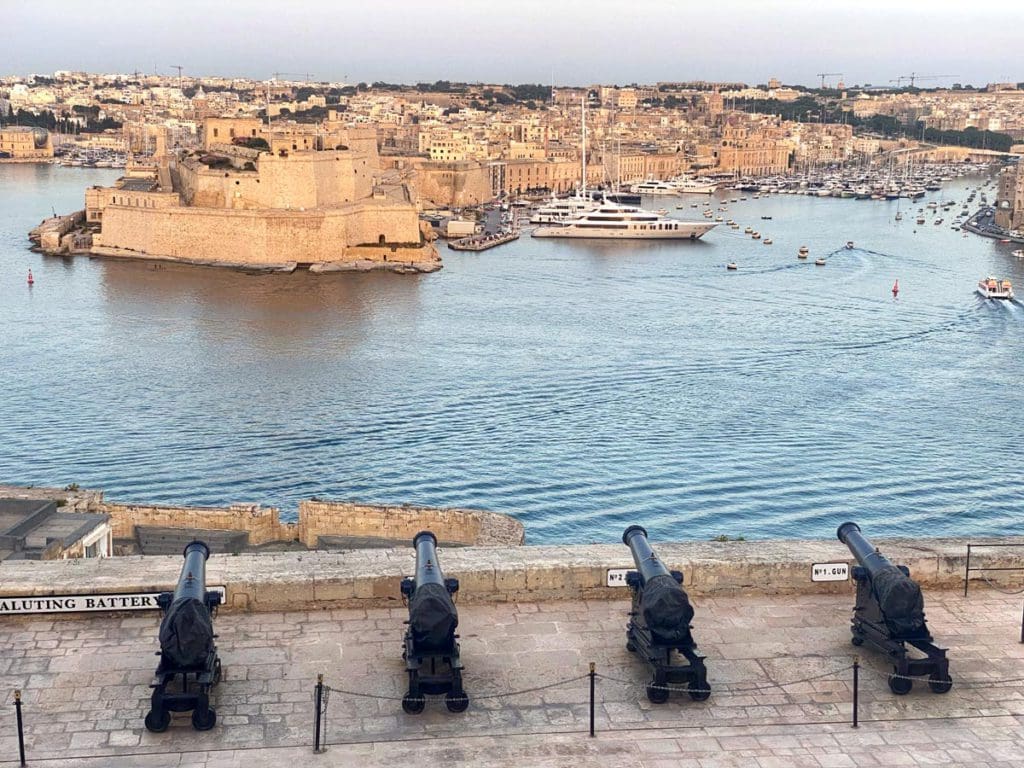 Four historic cannons face the water in one of Malta's old ports.