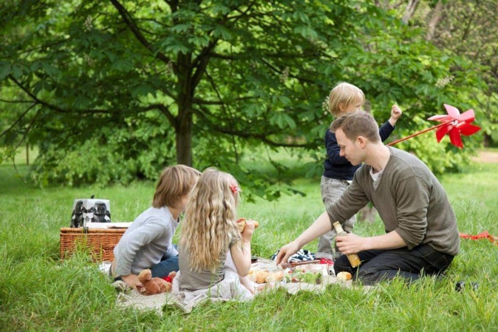 A dad and his three young kids have a picnic, courtesy of The Athenaeum Hotel & Residences.