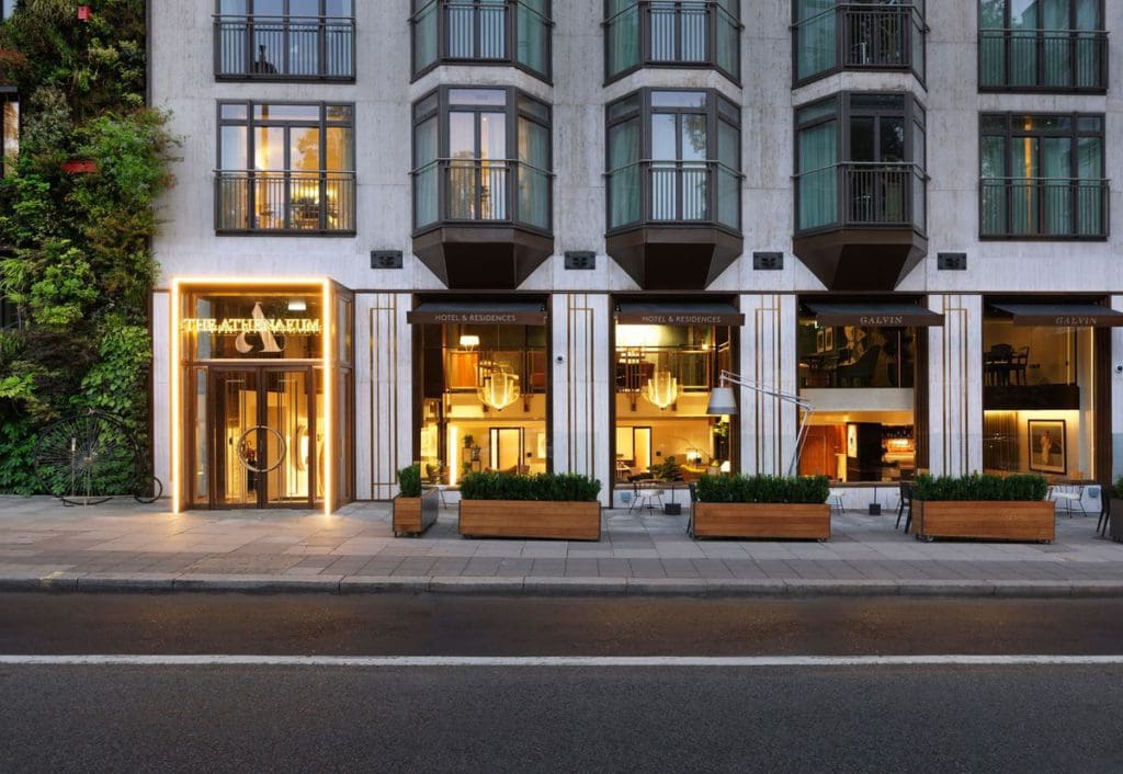 The entrance to The Athenaeum Hotel & Residences, lit up at night.