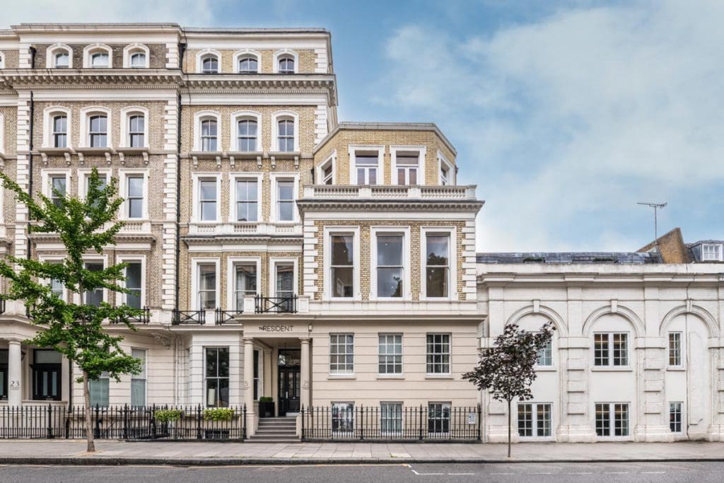 The exterior entrance to the stately The Resident Kensington on a sunny day.