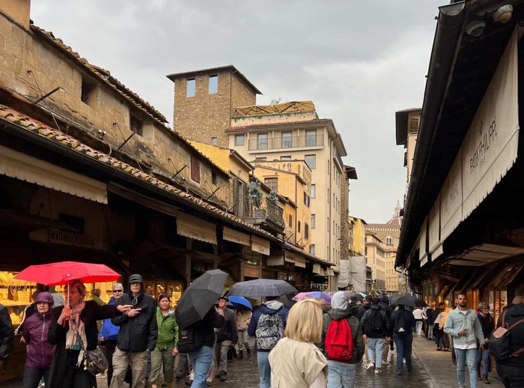 People walk across Ponte Vecchio in Florence.