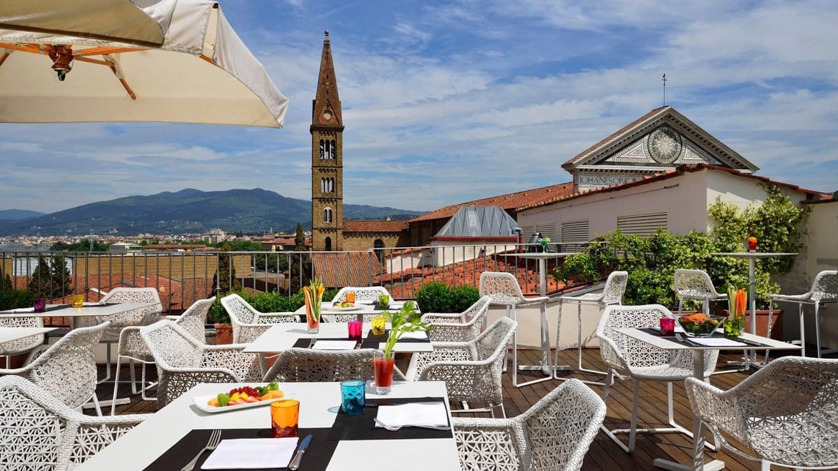 The rooftop of Grand Hotel Minerva, set for lunch service with a view of Florence below.