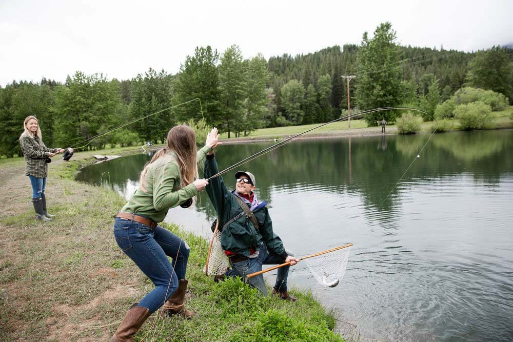 A man and a woman high-five as they fish the shores of Greenhorn Ranch.