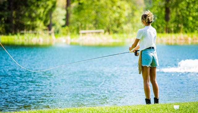 A young woman casts a line into the lake at Greenhorn Ranch.