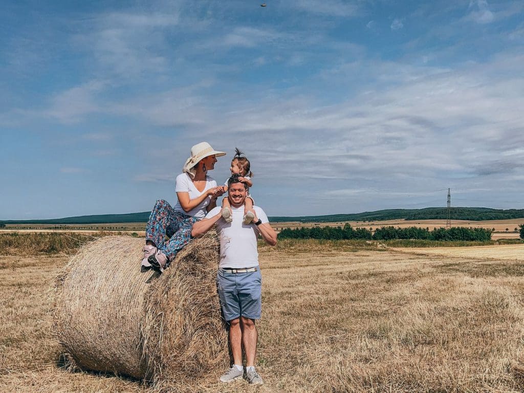 A family of three, wearing matching outfits, poses together, while on a European family vacation - matching clothes are a must-pack for a European vacation with toddlers.