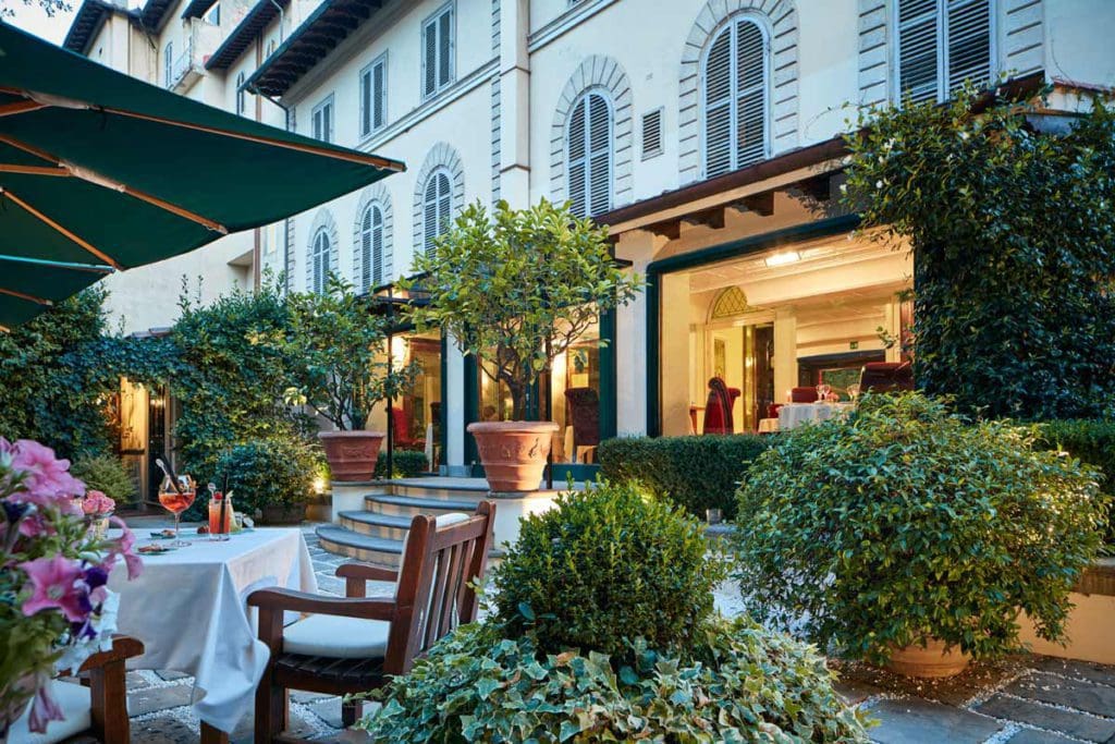 The lovely outdoor garden cafe area of Hotel Regency, with the hotel entrance behind it.