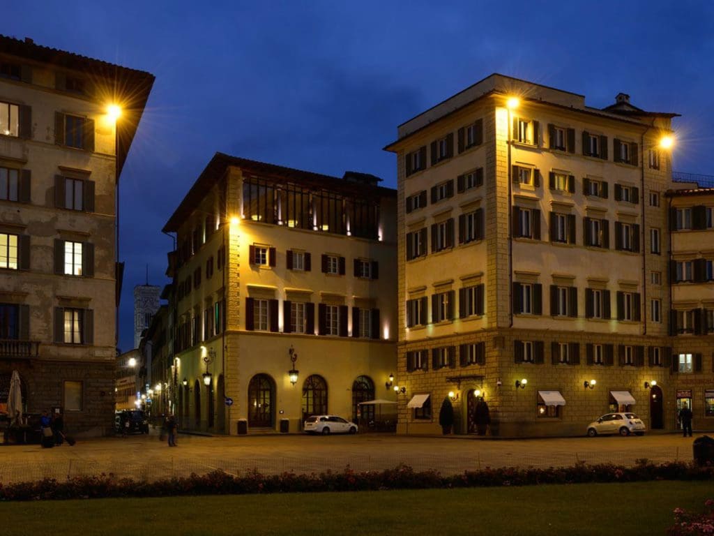A view of Hotel Santa Maria Novella, lit up at night.