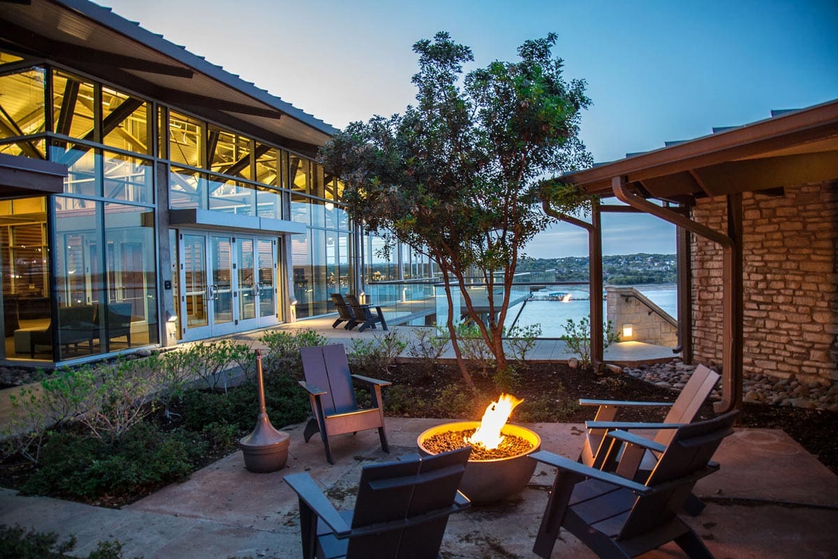 Three empty chairs sit around a fire pit at Lakeway Resort and Spa, one of the best hotels in Austin for families.