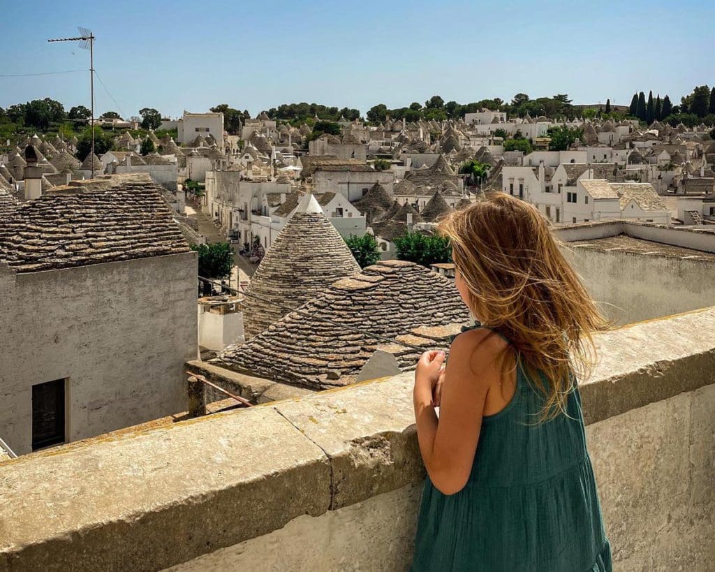 A young girl looks over a view of the trulli roofs in Alberobello.