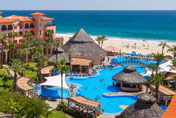 One of the pools, with cozy cabanas, at Royal Solaris Los Cabos with the ocean in the distance.