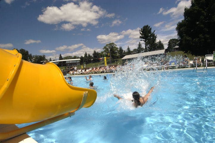 A woman shoots out of the mouth of a water slide at Sunny Hill Resort and Golf Course, one of the best all-inclusive hotels in the United States for families.